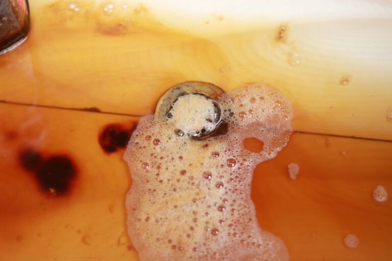 Water pooling around a clogged kitchen sink drain